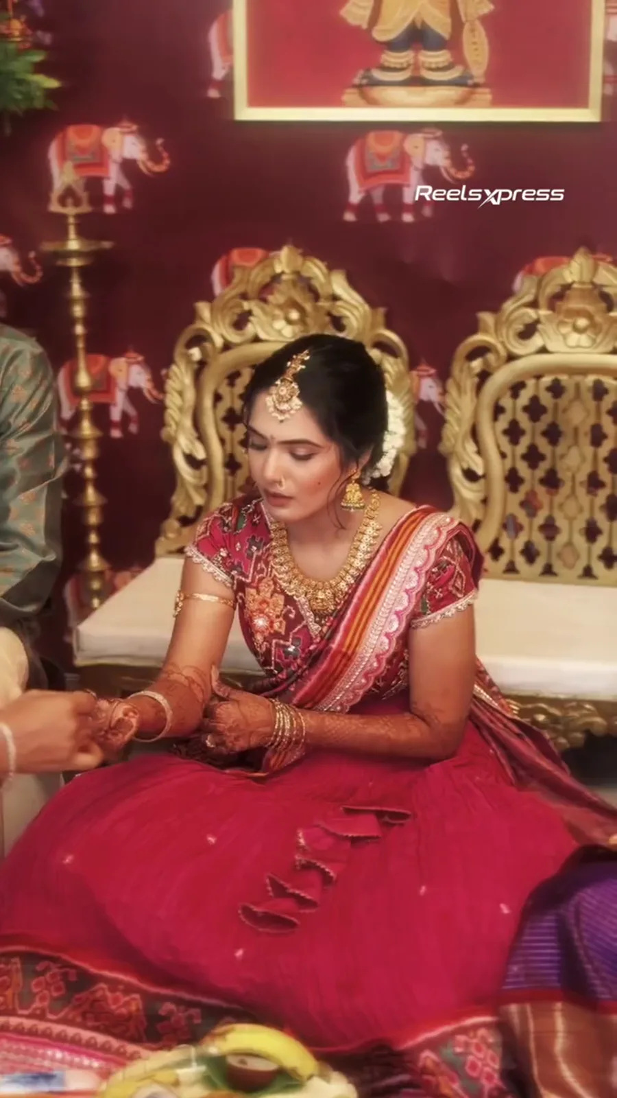 Bride looking down at her mehndi during a Pellikuthuru ceremony